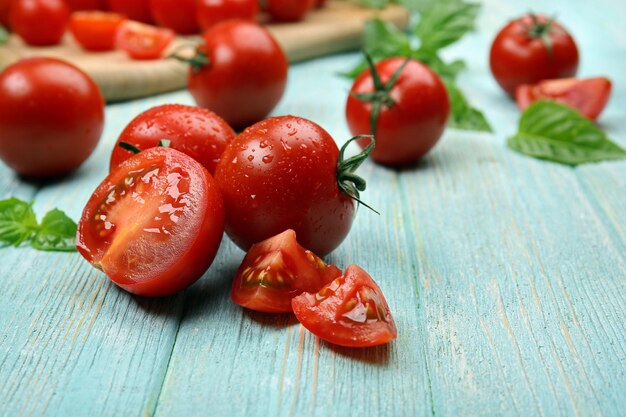 Tomates fraîches au basilic sur table en bois se bouchent