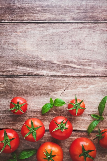 Tomates fraîches et basilic sur fond de cuisine en bois vue de dessus espace de copie