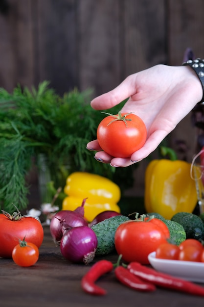 Tomates fraîches, concombres, poivrons, oignons sur la vieille table rustique