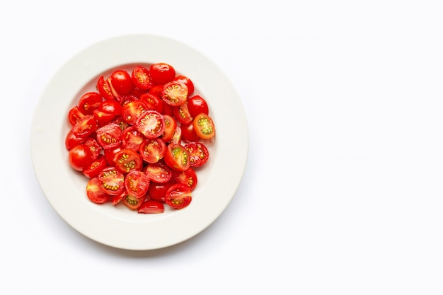 Tomates fraîches, coupées à moitié dans un plat blanc.