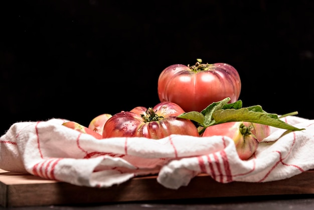 Tomates fraîches dans une assiette sur fond sombre Récolte des tomates Vue de dessus