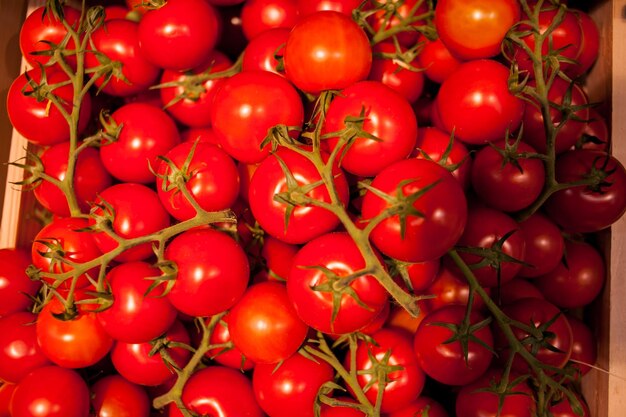 Tomates fraîches à l'épicerie Délicieuses tomates rouges Pile de fond de tomates