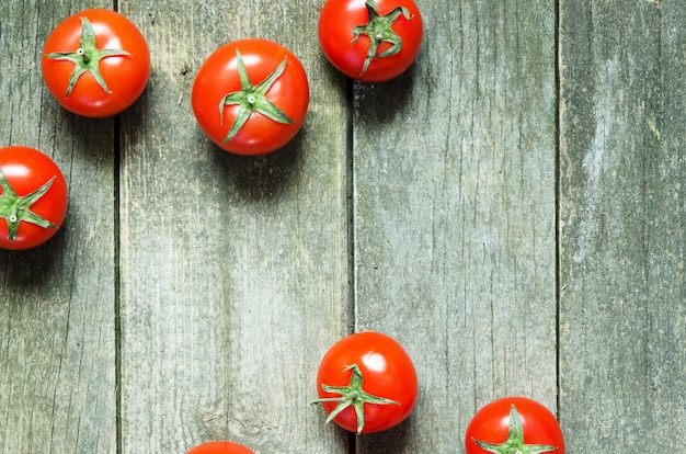 Tomates fraîches sur fond en bois rustique