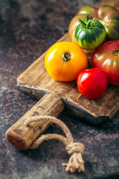 Tomates fraîches et mûres multicolores sur fond sombre.