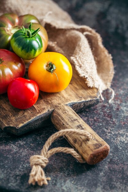 Tomates fraîches et mûres multicolores sur fond sombre.