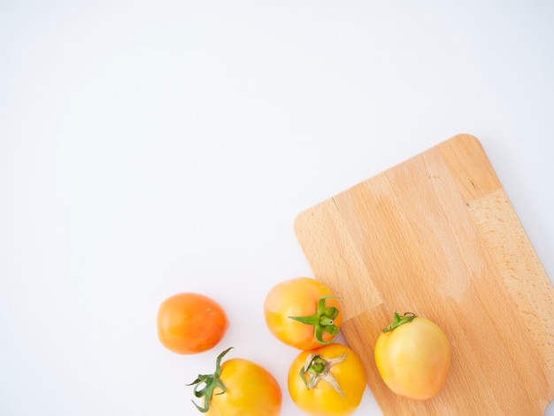 Tomates fraîches sur une planche à découper en bois.