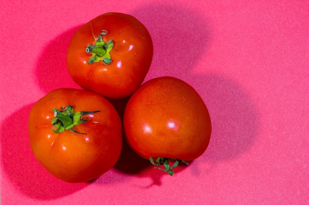 Tomates fraîches présentées sur fond rouge concept de minimalisme créatif avec espace de copie