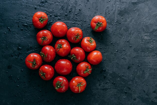 Tomates fraîches rouges mûres avec des gouttes d'eau