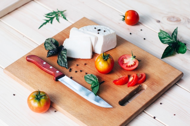 Tomates fromage basilic sur planche à découper en bois