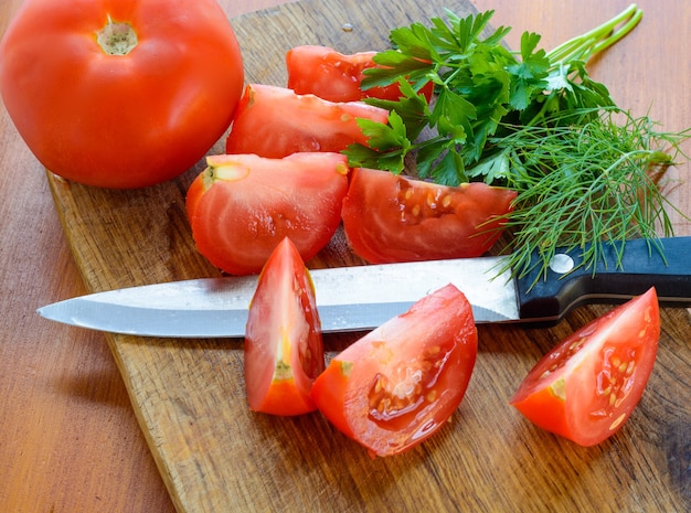 Tomates hachées et couteau sur planche à découper