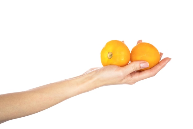 Tomates jaunes mûres dans les mains isolés sur fond blanc