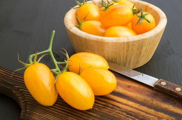 Tomates jaunes sur une planche de bois.