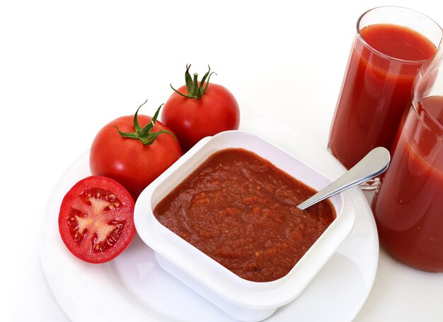 Tomates et jus de tomate isolé sur blanc.