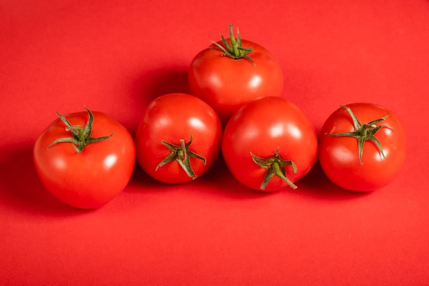 Tomates juteuses sur une surface rouge vif