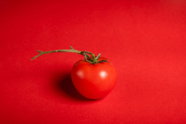 Photo tomates juteuses sur une surface rouge vif