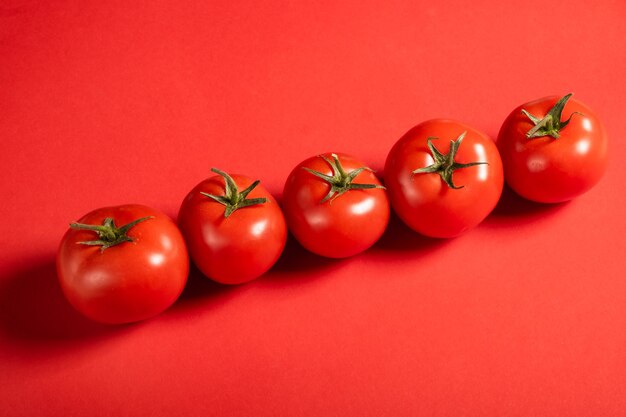 Tomates juteuses sur une surface rouge vif