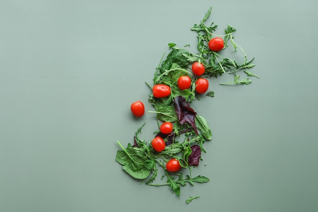 Tomates et légumes verts pour salade sur fond vert Concept de nourriture à plat