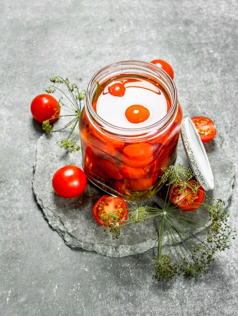 Tomates marinées aux herbes. Sur un fond de pierre.