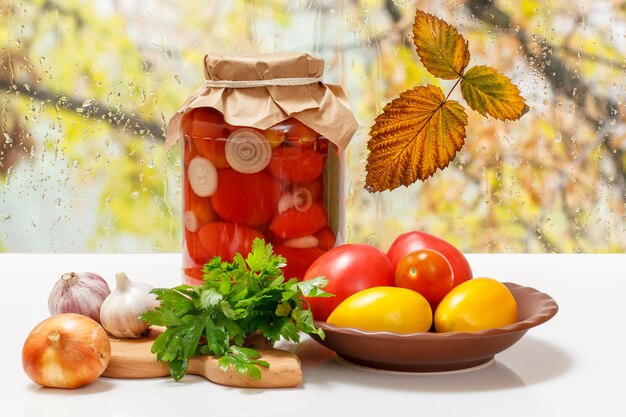 Tomates marinées dans un bocal en verre sur le rebord de la fenêtre.