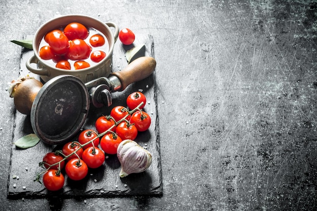 Tomates marinées dans un bol et une branche de tomates fraîches