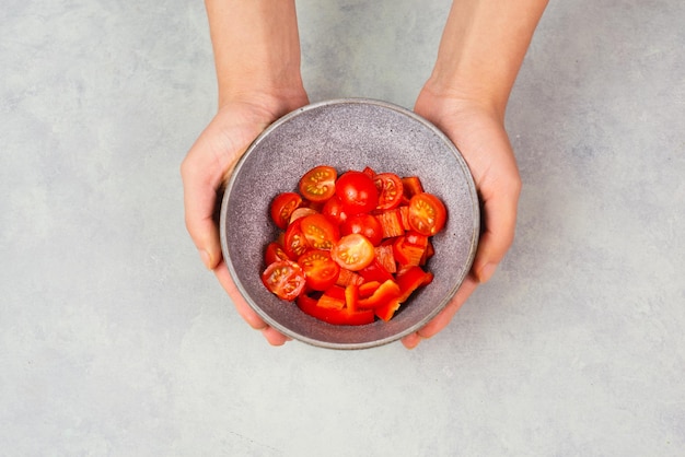 Les tomates et les morceaux de poivron rouge tranchés dans un bol préparent des aliments sains avec des légumes paprika