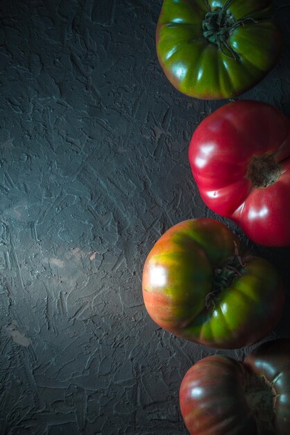 Tomates multicolores sur une ligne grise de fond du côté droit