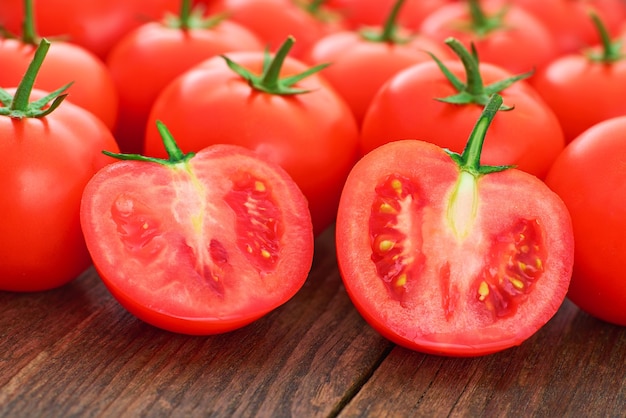 Tomates Mûres Entières Et Tranchées Sur Une Table En Bois, Gros Plan.
