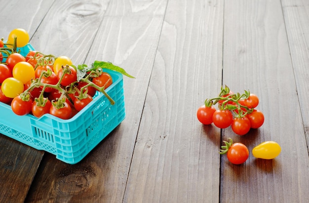 Les tomates mûres fraîches sont dans les boîtes sur une table en bois broun