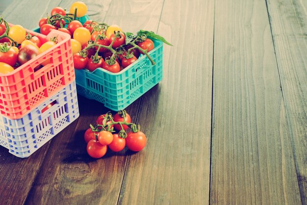 Les tomates mûres fraîches sont dans les boîtes sur une table en bois broun