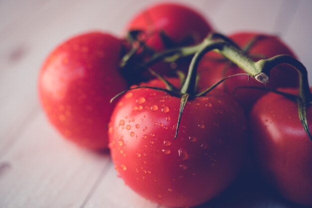 Tomates mûres avec des gouttes d'eau sur la table