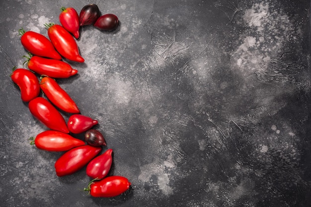 Tomates mûres poivrées au sommet d'une toile texturée foncée copie spce vue de dessus Solanum lycopersicum fruits