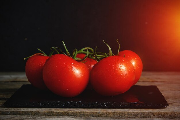 Tomates mûres rouges sur une ardoise avec un soleil éclatant