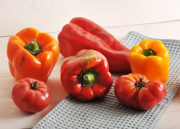 Tomates et poivrons sur une surface en bois