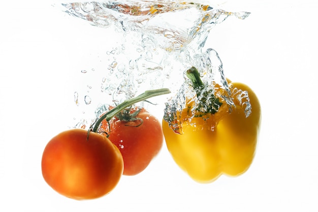 Tomates et poivrons tombent dans l'eau avec un soupçon