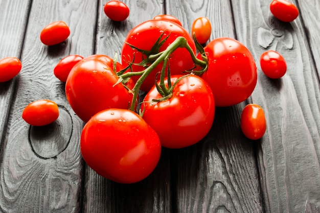 Tomates rouges sur une branche sur un fond noir