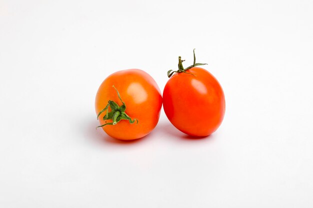 Tomates rouges, brillantes, juteuses et fraîches isolées