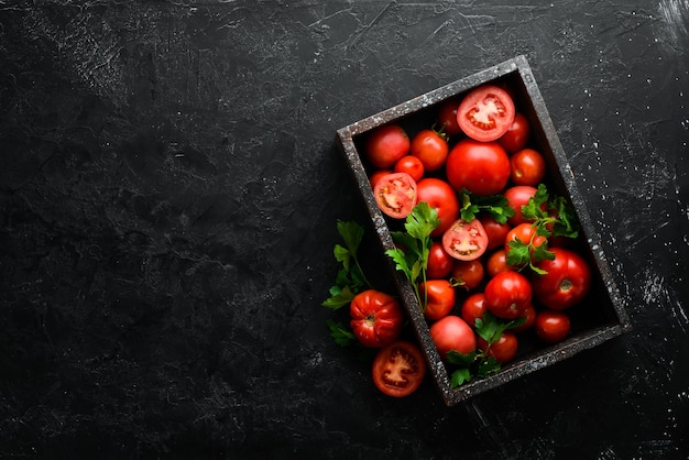 Tomates rouges fraîches en boîte sur fond de pierre noire Légumes Vue de dessus Espace libre pour votre texte