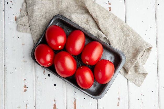 Tomates rouges fraîches, gros plan de tomates fraîches et mûres sur fond de bois
