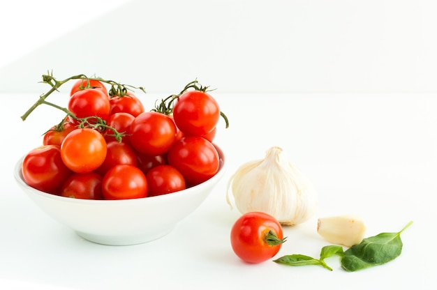 Tomates rouges italiennes bouchent les aliments avec des feuilles de basilic à l'ail isolés sur fond blanc