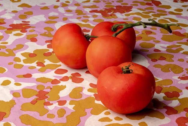 Tomates rouges juteuses sur une table colorée.