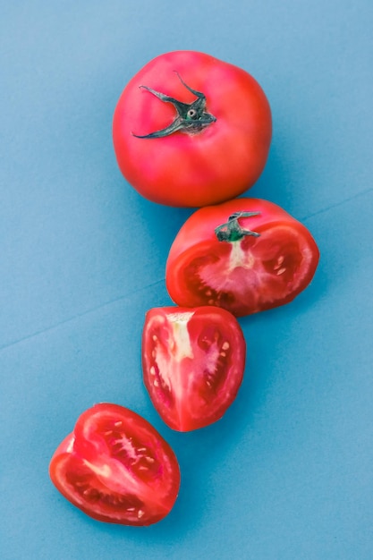 Tomates rouges mûres fraîches sur fond bleu aliments végétaux biologiques