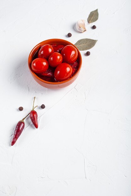 Tomates rouges salées avec des ingrédients sur un tableau blanc