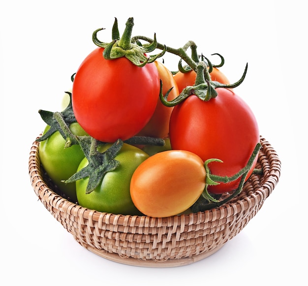 Tomates rouges, vertes et jaunes dans le panier sur fond blanc