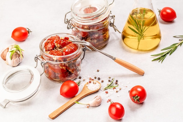 Tomates séchées au soleil avec des herbes fraîches et des épices dans de l'huile d'olive dans un bocal en verre Fond de recette alimentaire. espace pour le texte. vue de dessus.