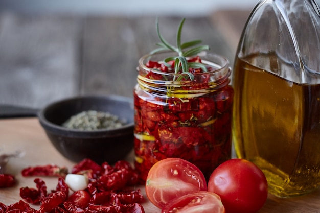 Tomates séchées aux herbes de Provence, ail et huile d'olive sur une surface en bois rustique, mise au point sélective