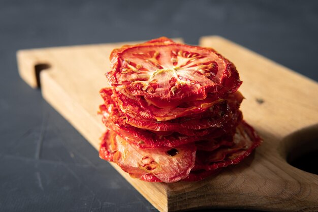 Les tomates séchées sont sur un fond sombre dans la cuisine.