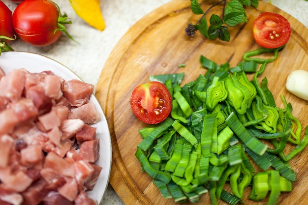 Les tomates sont sur le plateau, à côté des légumes et des tranches de viande.