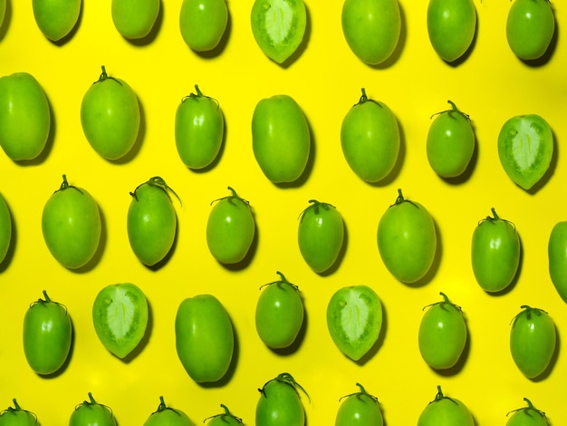 Tomates vertes sur un fond jaune Le concept d'un légume immature Arrière-plan à partir de légumes verts Produit de salage