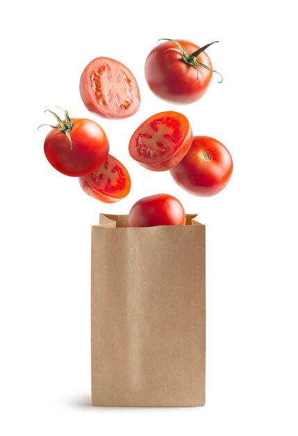 Tomates volantes, sac en papier recyclable, isolé du fond blanc