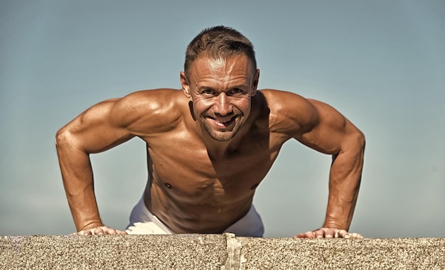 Tombez pour la santé faites votre premier pas L'homme s'entraîne à la force musculaire L'homme en forme fait des exercices musculaires Le sport et les soins de santé Le sport est une obsession pour lui